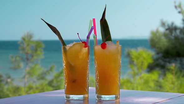 Two glasses of iced fruit drinks on sea background Vacation time alt