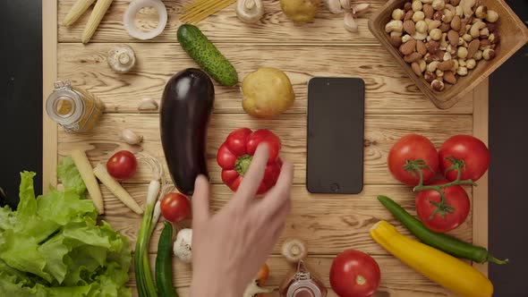 Faceless People Taking Vegetables From Table alt