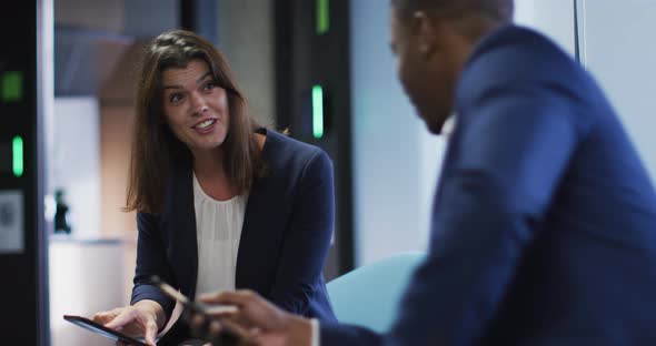 Diverse smiling businessman and businesswoman talking in modern office alt
