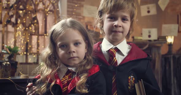 Portrait of Two Little Students of the Wizard School with Book in Class alt