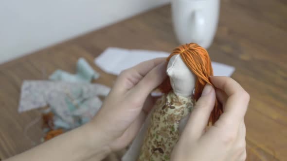 Women Sews a Cute Cloth Doll