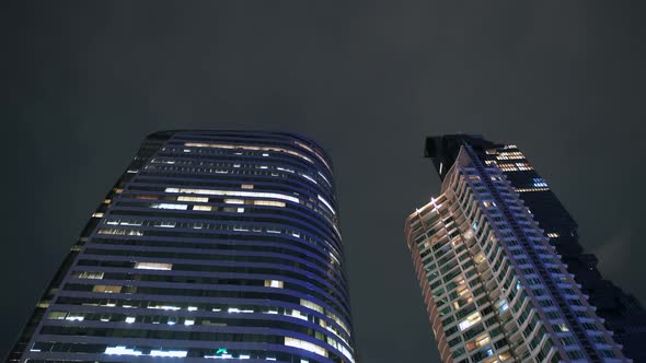 Modern Design Skyscrapers Illuminated at Night Time in City Center, Close Up