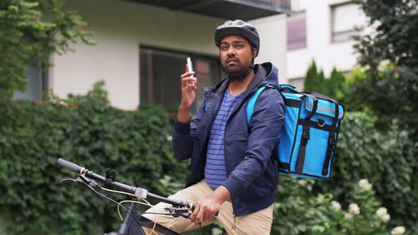 Delivery Man with Bag and Bicycle Calling on Phone alt