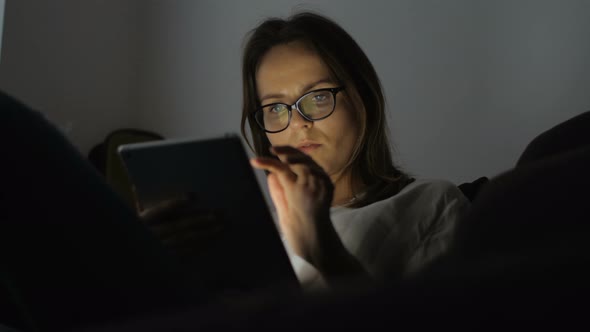 Woman Using Tablet Device In Dark Room