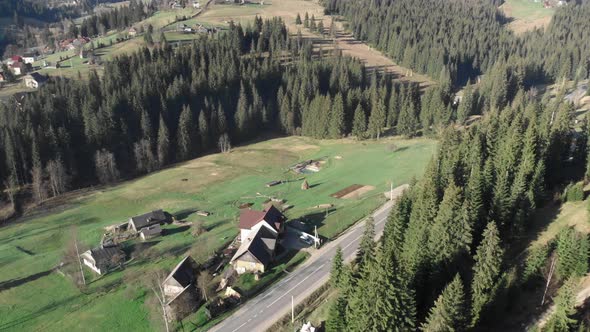 Cottages in mountains, aerial drone view. Mountains with pine trees forest. alt
