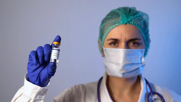 Female Doctor Handles Vial of Coronavirus Vaccine alt