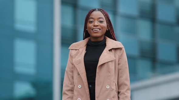 Serious Concentrated Young African American Girl with Afro Hairstyle Standing with Folded Hands alt