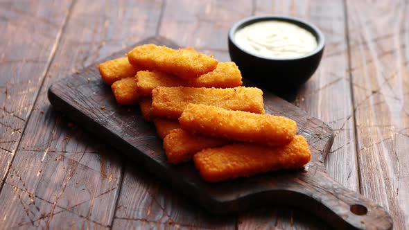 Pile of Golden Fried Fish Fingers with White Garlic Sauce alt