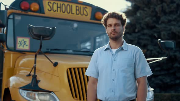 Thoughtful Bus Driver Standing in Front Yellow Vehicle Looking Camera Close Up alt