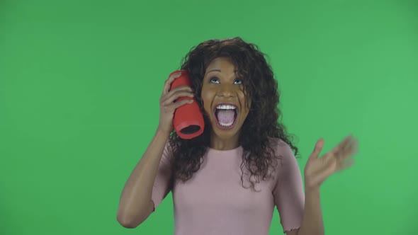 Portrait of Beautiful African American Young Woman Is Looking at Camera and Listening To Music with alt