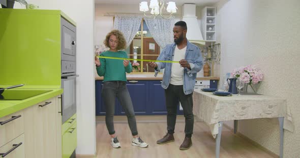 Young Multiethnic Couple Buying Kitchen Garniture in Furniture Store alt