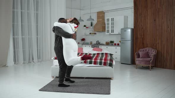 Joyful Man Circling Curvy Girlfriend in His Arms alt