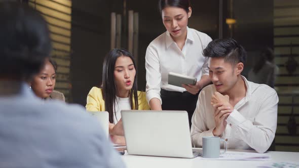 Asian young business people have discussion meeting and brainstorming overwork in office at night. alt