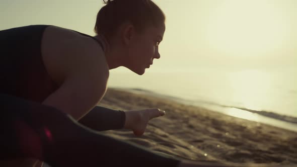 Sportswoman Making Gymnastics Exercises on Beach alt