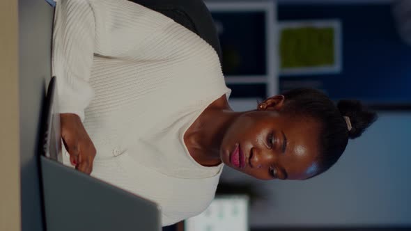 Stressed African Manager Woman Working with Financial Graphs Overtime alt