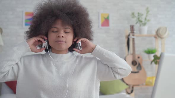Portrait African American Woman with an Afro Hairstyle Listening To Music with Headphones alt