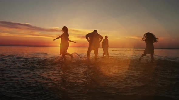 Group of Happy People Stands and Playing in Water at the Beach on ...