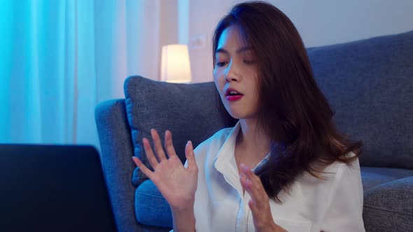Asian businesswoman using laptop talk to colleagues about plan in video call while working. alt