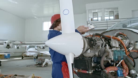 Female Technician Testing Jet Engine alt