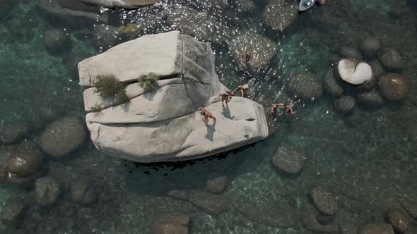 Beautiful group of young ladies jumping from the rock alt