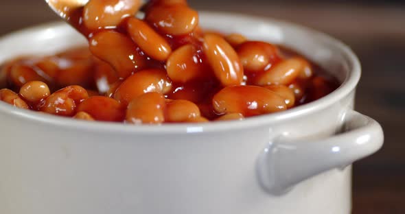 The Beans in the Tomato Sauce in the Bowl Slowly Rotate. Macro Background. alt