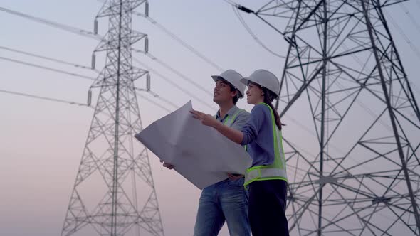 Two specialist electrical engineer working near to High voltage tower.