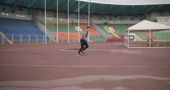 Sportsman Doing High Jump on Stadium alt