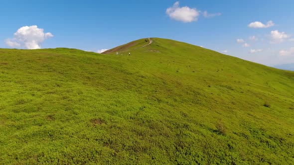 Aerial flight over green hill mountains. FPV Dynamic drone shot alt