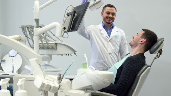 Dentist and Male Patient Show Their Thumbs Up