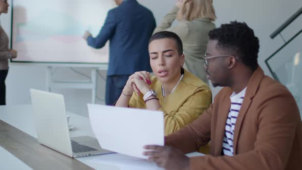 Handsome young African American business man and short hair woman working on laptop