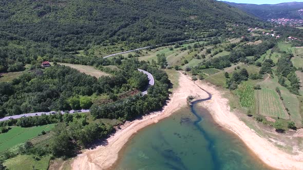 Flying above forested shore of artificial lake Peruca, Croatia alt