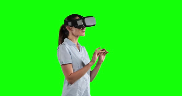a Caucasian woman wearing 3D goggles in a green background