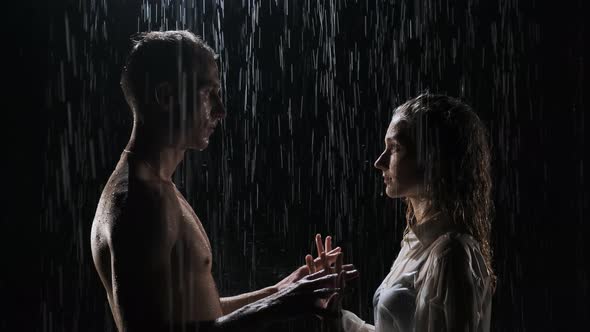 Beautiful Couple of Man and Woman Stand in the Rain and Join Hands. The Concept of Happy alt
