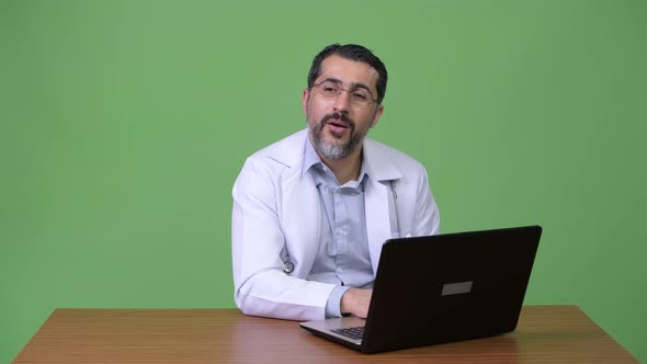 Handsome Persian Bearded Man Doctor Working with Laptop and Greeting