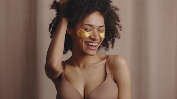 Cute Flirty Positive African American Woman with Golden Undereyes Patches Posing to Camera and alt