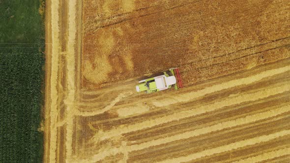 Aerial Horizontal Drone View of a Modern Combine Harvester Reaping Wheat