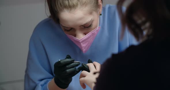 Manicurist Applies Gel Lacquer to the Nails of the Client at Beaty Salon Cosmetology and Beauty alt