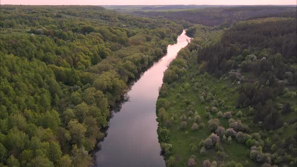 View of the river from above. Flight over water and forest trees from a height alt