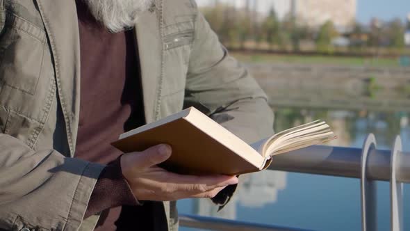Closeup of Senior Male Caucasian Hands Holding Book alt