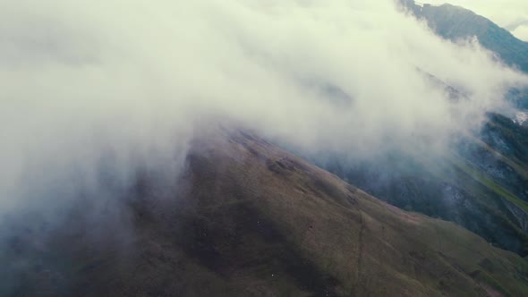 Aerial View of a Mountain Slope Covered with Clouds alt