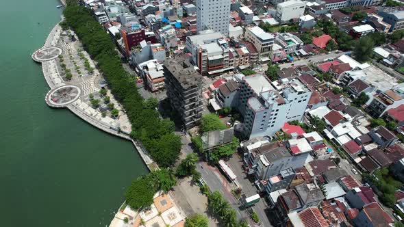 drone flying over Makassar city Sulawesi Indonesia during a sunny day with traffic and buildings bel alt