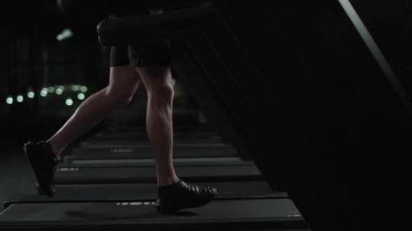 Ypung Athletic Man Run on a Treadmill Aerobic Exercise and Endurance Training in the Gym Night alt