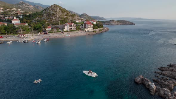 Aerial View of the Motor Boat Sails to the Bay in the Old European Town in Mountains