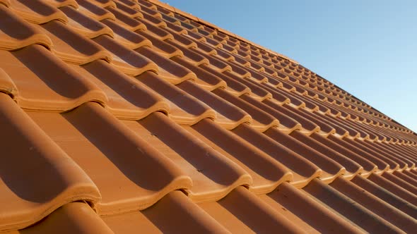 Overlapping Rows of Yellow Ceramic Roofing Tiles Covering Residential Building Roof alt