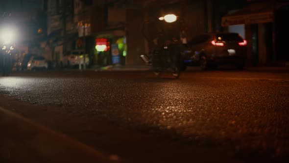 Closeup at Night Drops of Summer or Autumn Rain Fall on the Asphalt in the City Turning Into a Large alt