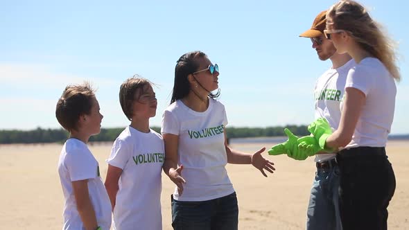 Volunteers in Tshirt Talk Family Recycle Plastic Bottle Planning Cleanup Teamwork alt