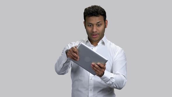 Very Exctied Darkskinned Guy Playing Video Game on His Tablet Pc alt