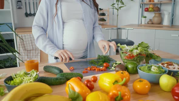 Pregnant Woman Preparing Organic Healthy Food Slicing Vegetables for Salad alt