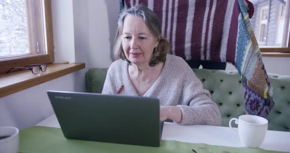 a Loving Elderly Husband Covers His Old Mature Wife with a Blanket While She Works on the Computer alt