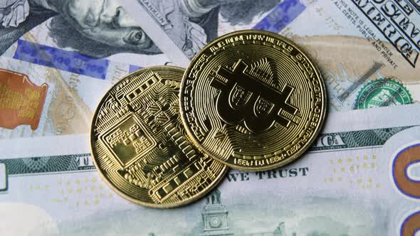 Bitcoin BTC coin rotate on 100 dollars USD bills. blockchain, mining GPU alt